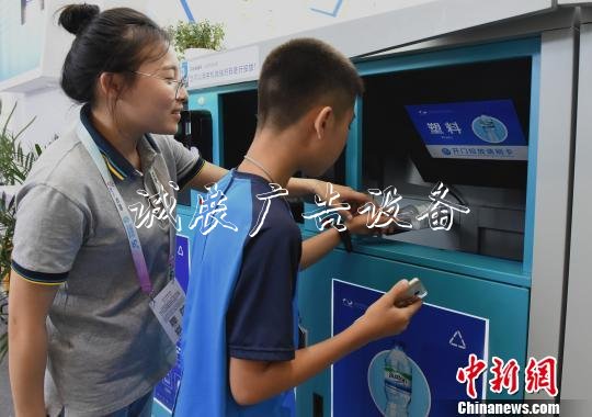 圖為小朋友感受用智能垃圾箱掃碼扔垃圾。　周毅　攝