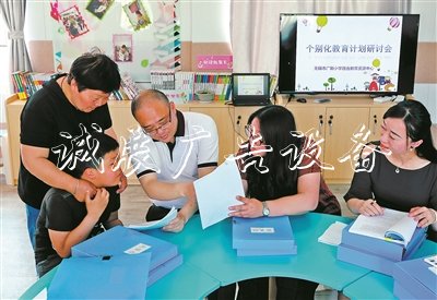 無(wú)錫市廣新小學(xué)校長(zhǎng)過(guò)秦勇（右三）、副校長(zhǎng)朱甄珍（右一）與梁溪區(qū)特教指導(dǎo)中心資源教師陳向華（右二），和學(xué)生小芮及家長(zhǎng)一起商量個(gè)別化教育方案。